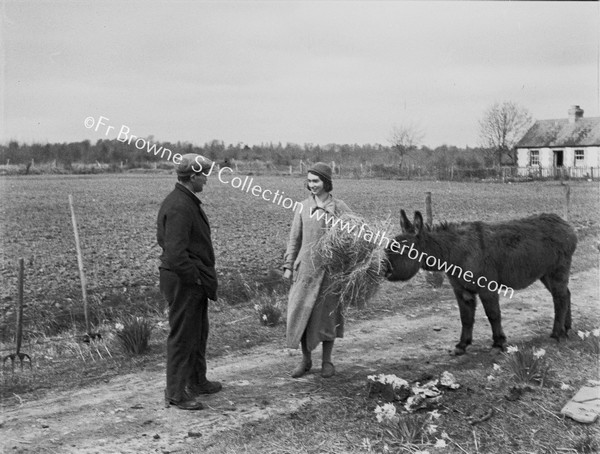 FARMER WITH WIFE FEEDING DONKEY